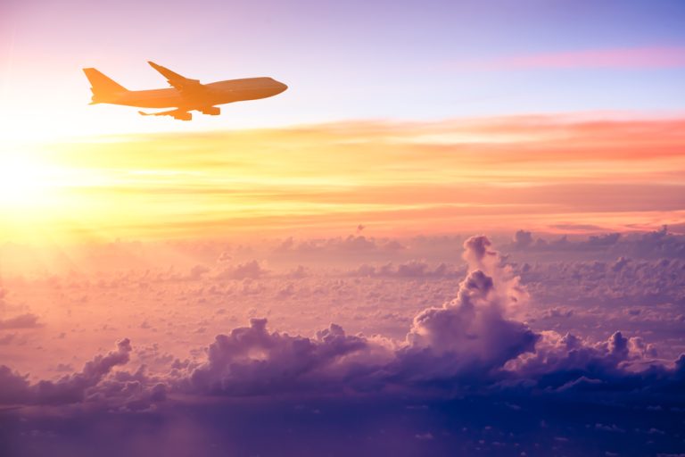 airplane flying at sunset